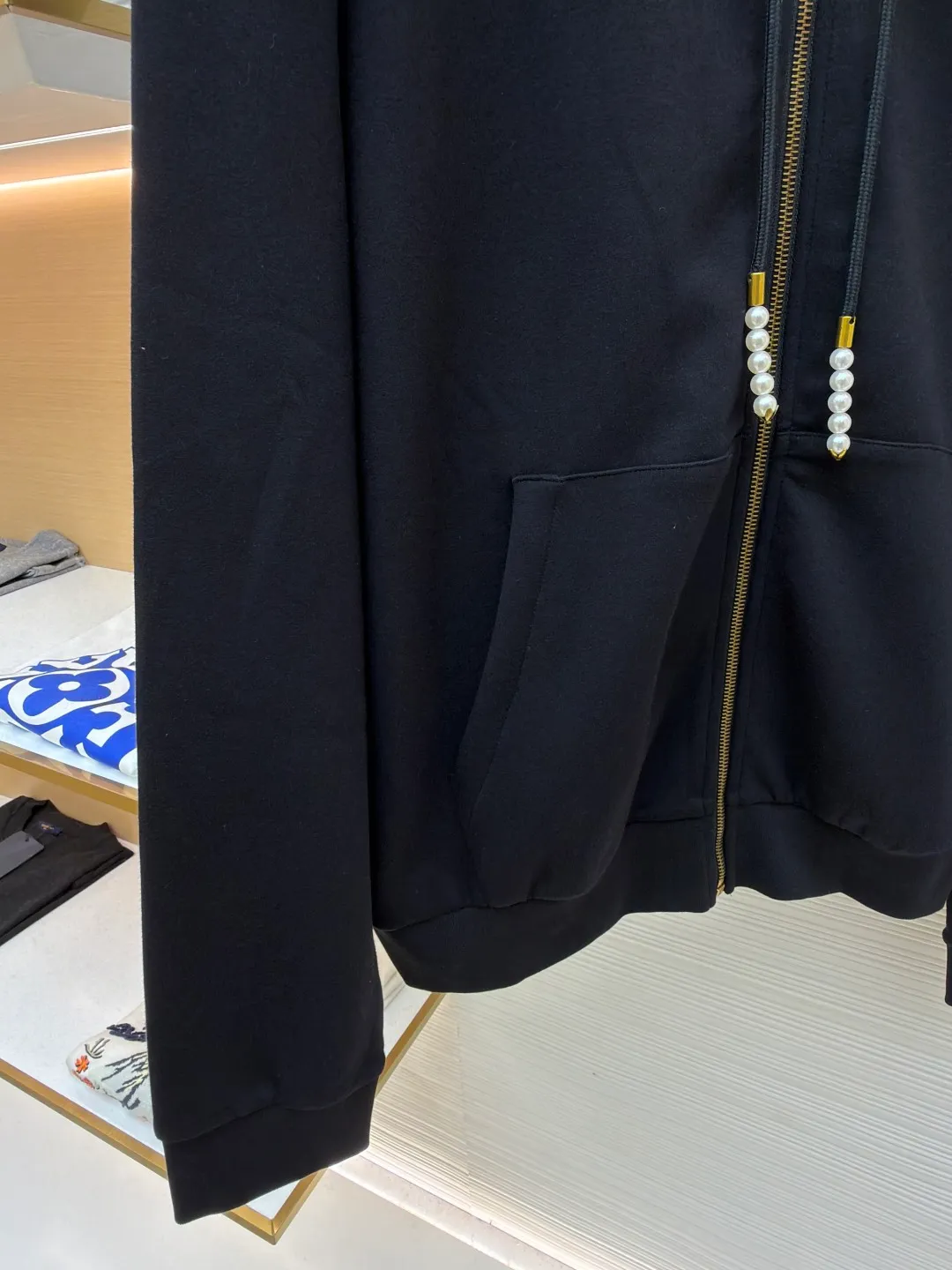 LOUIS VUITTON Pearl Pendant Zipper Jacket ●Original version: Purchased and developed for 10999 ●Item number: 1682253-B60 ●Fabric: wool blended fabric ●Technology: knitted embroidery production ●Color: black ●Version: fitted version ●Weight: about 715 grams ●Size: S-M-L-XL ●Description: This Louis Vuitton black hooded zipper sweatshirt is made of high-weight pure cotton waffle fabric. The fabric has been combed and singed, with a uniform and fine surface texture. It is also treated with anti-pilling and pre-shrunk, making it soft to the touch and not easily deformed after long-term wear. The brand logo on the left side of the body adopts the same color dark pattern embossing process and is hot-pressed through a temperature-controlled mold. The pattern is low-key and has a strong three-dimensional effect. The drawstring is embellished with custom-made pearl decorations, which are fixed by hand-beading. The surface of the pearls is polished to have a good luster and will not fall off easily. The metal zipper is made of gold-plated brass and has been treated with antioxidant treatment. The chain head is engraved with the brand's classic logo, making it smooth and wear-resistant. The ribs on the cuffs and hem are made of spandex blended material, which has excellent resilience and is not easy to loosen. The overall design is cut with loose shoulders, combined with double-needle hemming and seamless splicing technology. The stitching is fine and flat, which not only ensures comfort, but also shows the exquisite craftsmanship and brand texture of high-end garments. The overall wiring is straight and delicate, the fabric is comfortable and soft, and the color is consistent without color difference. It can be matched with the same style to create a fashionable look and control various occasions. Customized accessories, complete with three standards, same style for men and women!